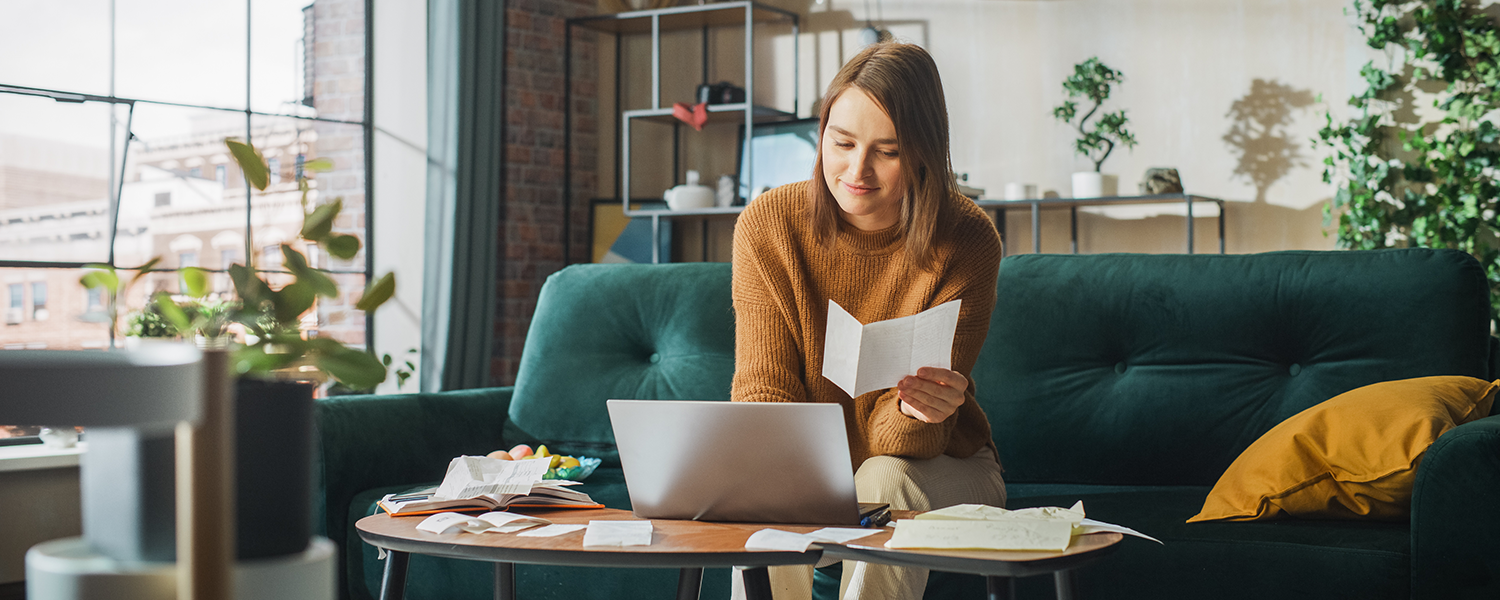 Woman on couch looking at tax documents