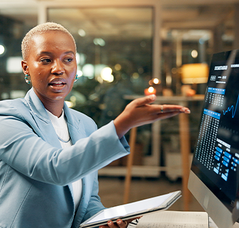 A woman showing her coworker a chart on the computer