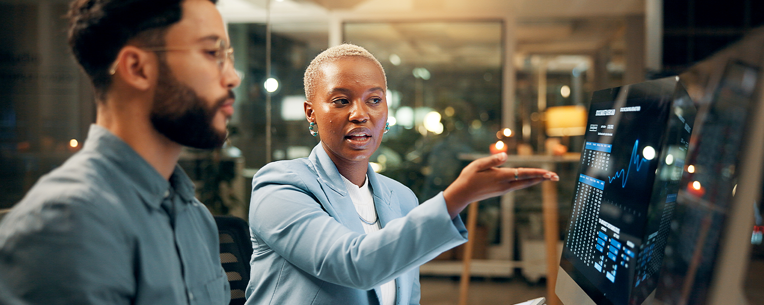 A woman showing her coworker a chart on the computer