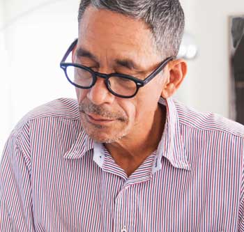 Man in striped shirt and glasses looking at paperwork
