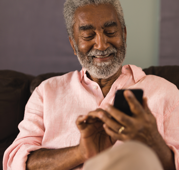 Man in pink shirt scrolling on his phone