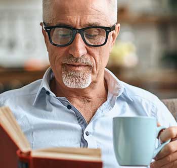 Man in glasses reading a book