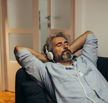 Man in grey shirt, wearing headphones