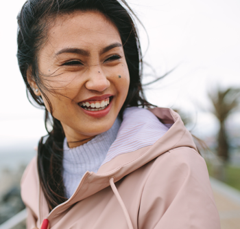 Woman smiling in light pink jacket